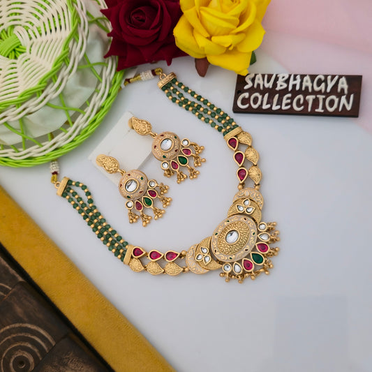 antique gold tone green beaded necklace set, traditional necklace with red green and white stones, multi strand green bead artificial jewellery, oval centrepiece ethnic necklace for women, red teardrop stone necklace with matching earrings, antique finish traditional Indian jewellery set, gold tone necklace with green beads and engraved motifs, festive wear necklace set for women