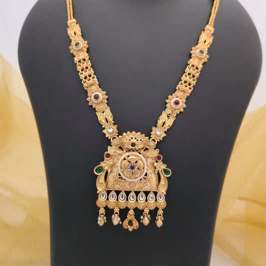 gold plated Rajwadi polish necklace set, traditional long necklace with ornate pendant, antique gold tone designer necklace for women, Rajwadi necklace with green and maroon stone accents, traditional necklace set with matching earrings, Indian wedding jewellery, festive ethnic necklace, artificial jewellery for women