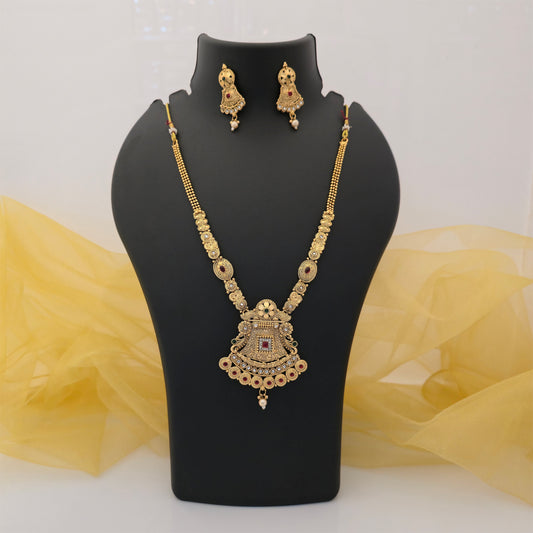 gold plated Rajwadi polish necklace set, traditional antique gold tone pendant necklace, designer Rajwadi artificial jewellery for women, intricate necklace with red stone accents, traditional pendant with pearl style drop, matching gold tone designer earrings, Indian wedding and festive necklace set
