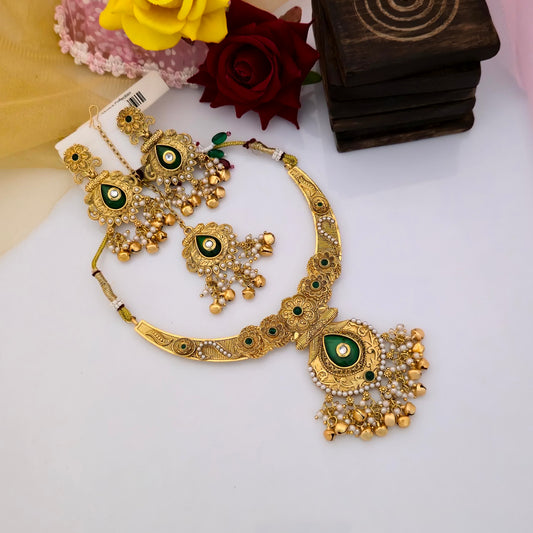 Gold plated Rajwadi polish short necklace set with green teardrop peacock motifs, intricate floral gold-tone detailing, white stone accents, decorative hanging beads and matching traditional earrings for women