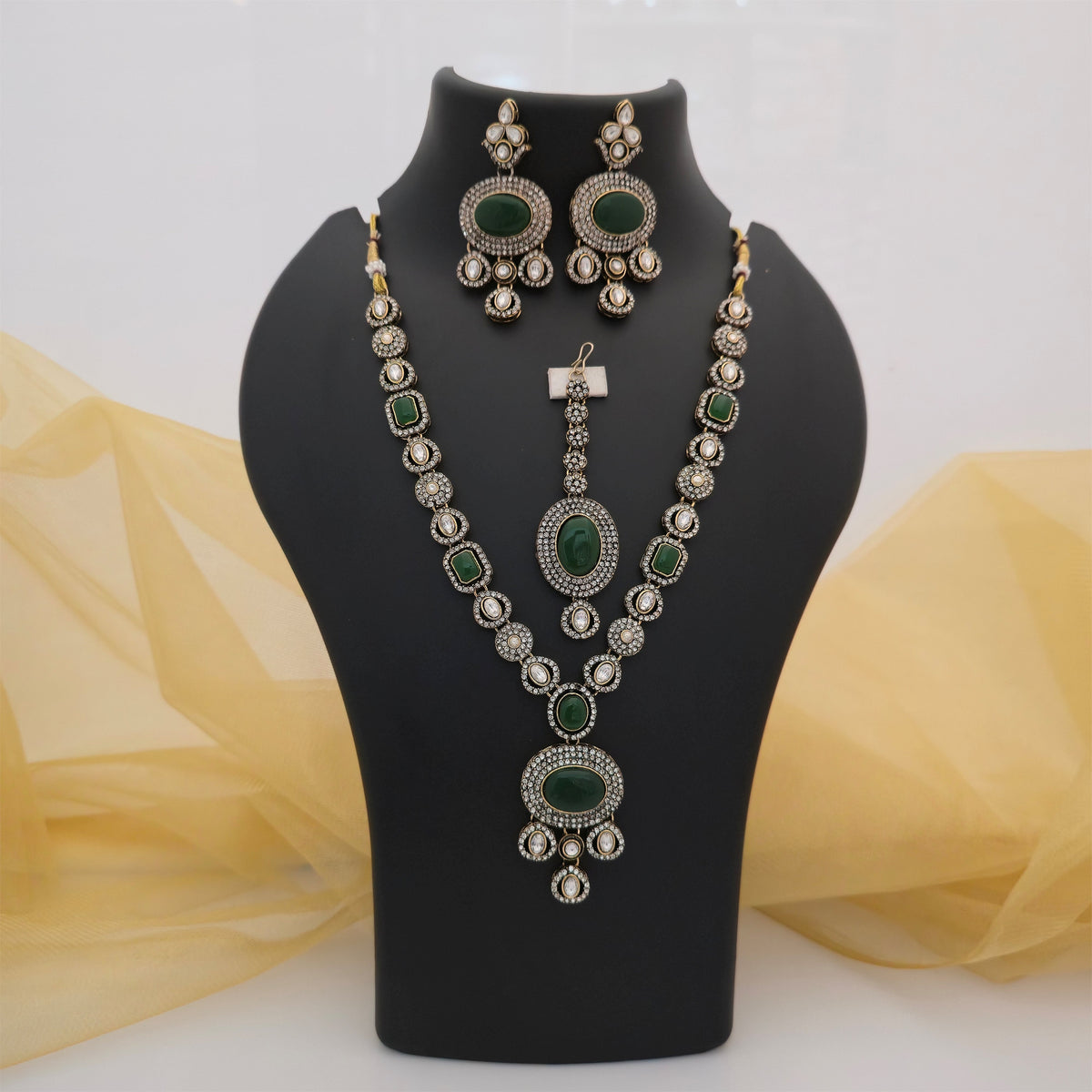 green AD and Moissanite necklace set with matching earrings and maang tikka, emerald green stone designer necklace for women, antique gold-tone traditional jewellery set, green and white statement necklace with matching earrings, Indian ethnic wedding jewellery set, green imitation jewellery for festive wear, Scofjewel green necklace set