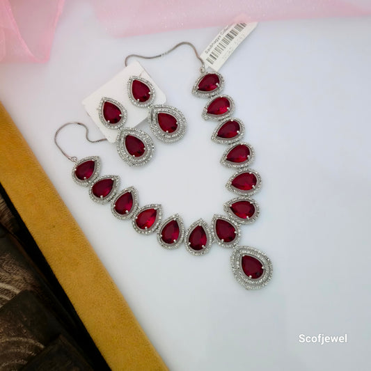 red AD teardrop necklace set with matching earrings, American Diamond necklace with red stones, silver tone designer necklace for women, red teardrop pendant necklace set, red stone imitation jewellery for weddings, elegant red party wear necklace with earrings, traditional red necklace set for women, Scofjewel red AD necklace