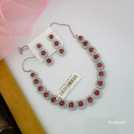 ruby red and white AD stone necklace set with matching earrings, red round stone necklace for women, silver tone designer necklace set, ruby red artificial jewellery set, elegant red necklace with matching drop earrings, red imitation jewellery for wedding and festive wear, Scofjewel red stone necklace set