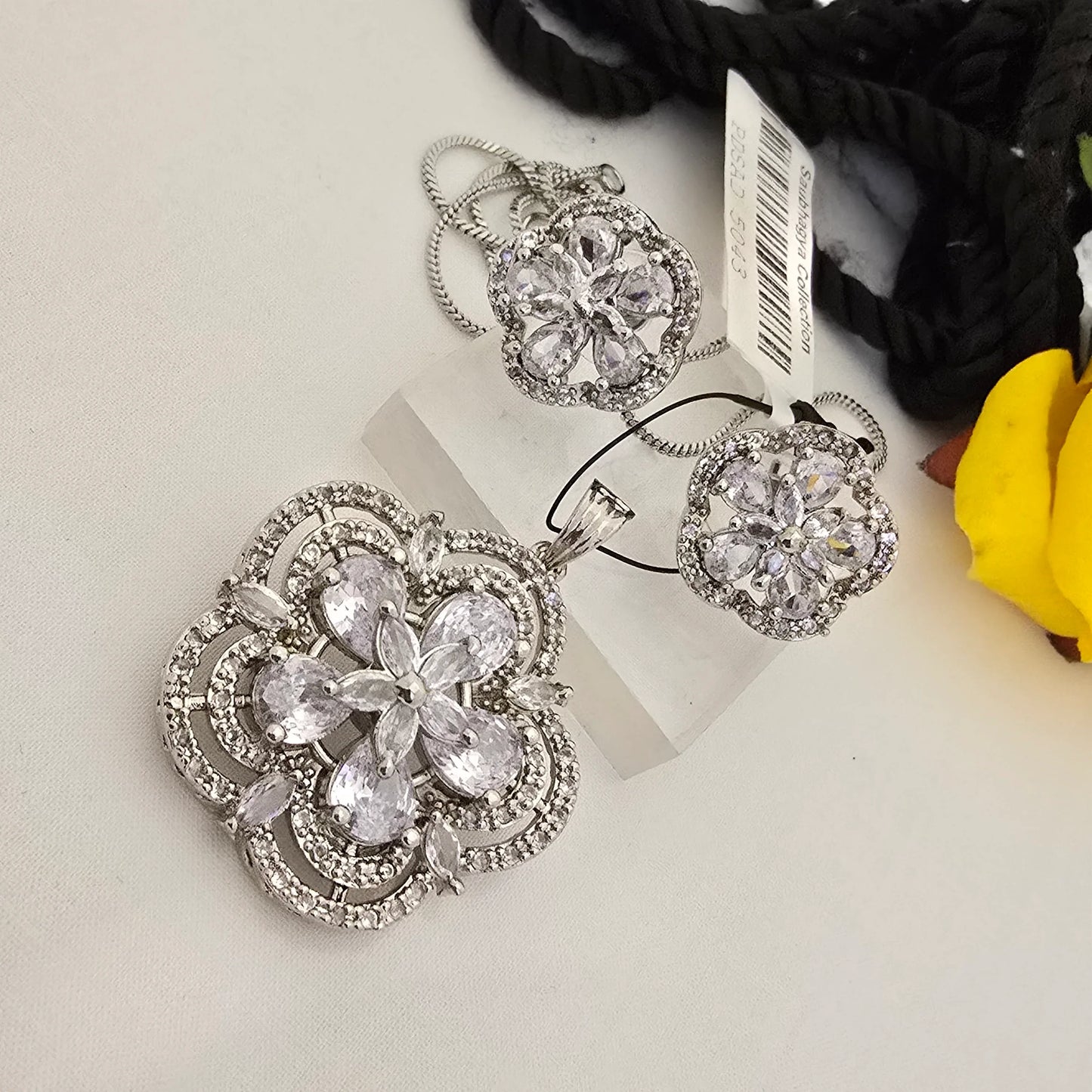 Silver_floral_jewelry_set_with_clear_stones_on_a_white_surface - Saubhagya Collection 