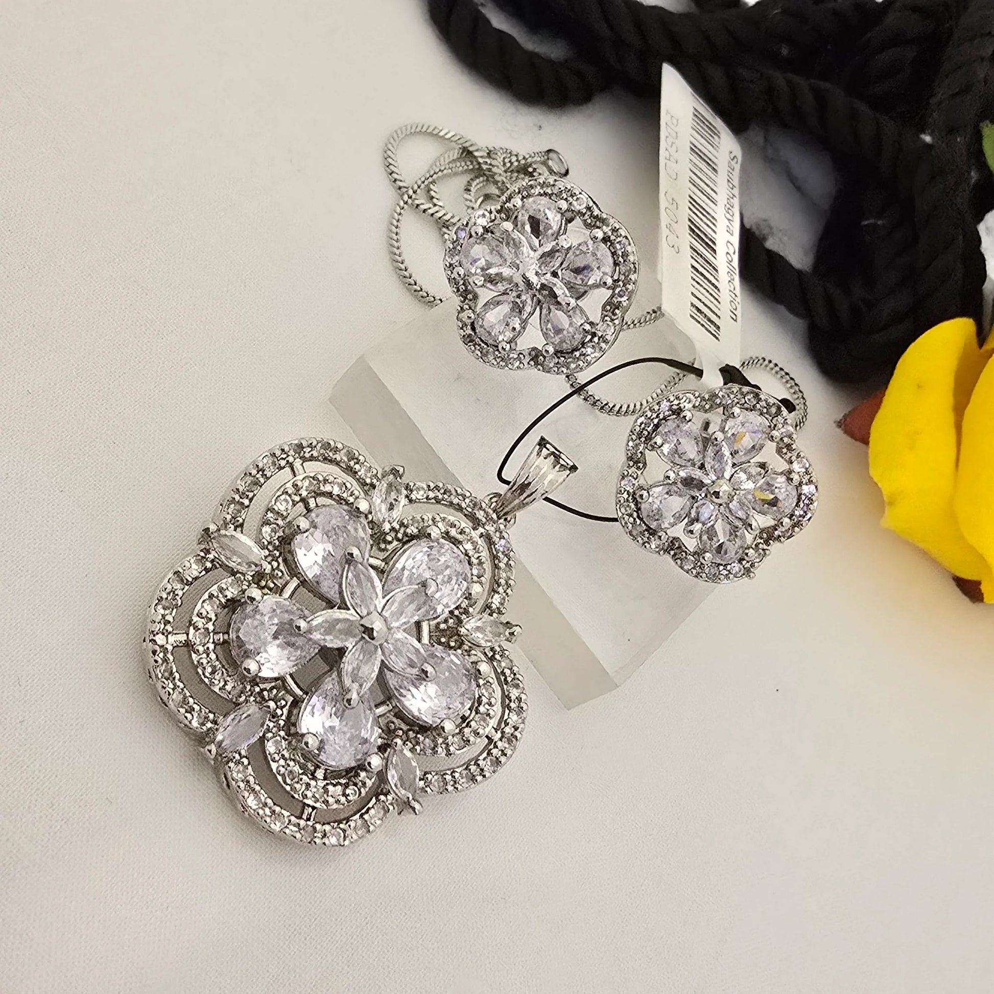 Silver_floral_jewelry_set_with_clear_stones_on_a_white_surface - Saubhagya Collection 